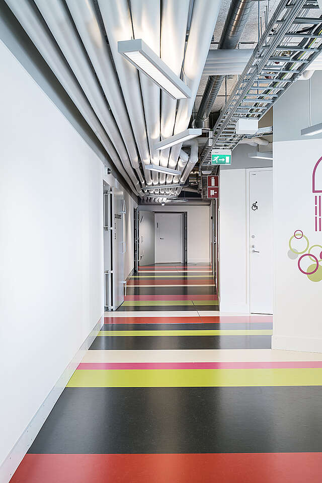 Hallway with a colorful striped floor.
