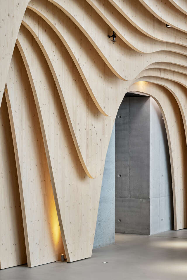 Wall with curved wooden elements. Doorway in middle.