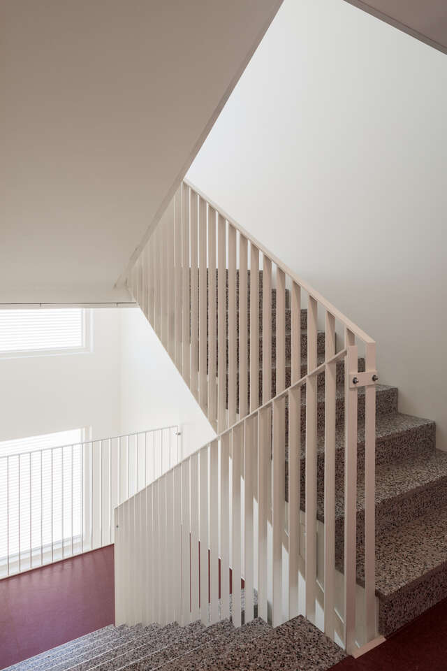 A stairwell inside an apartment building. The stairwell levels have a red floor.