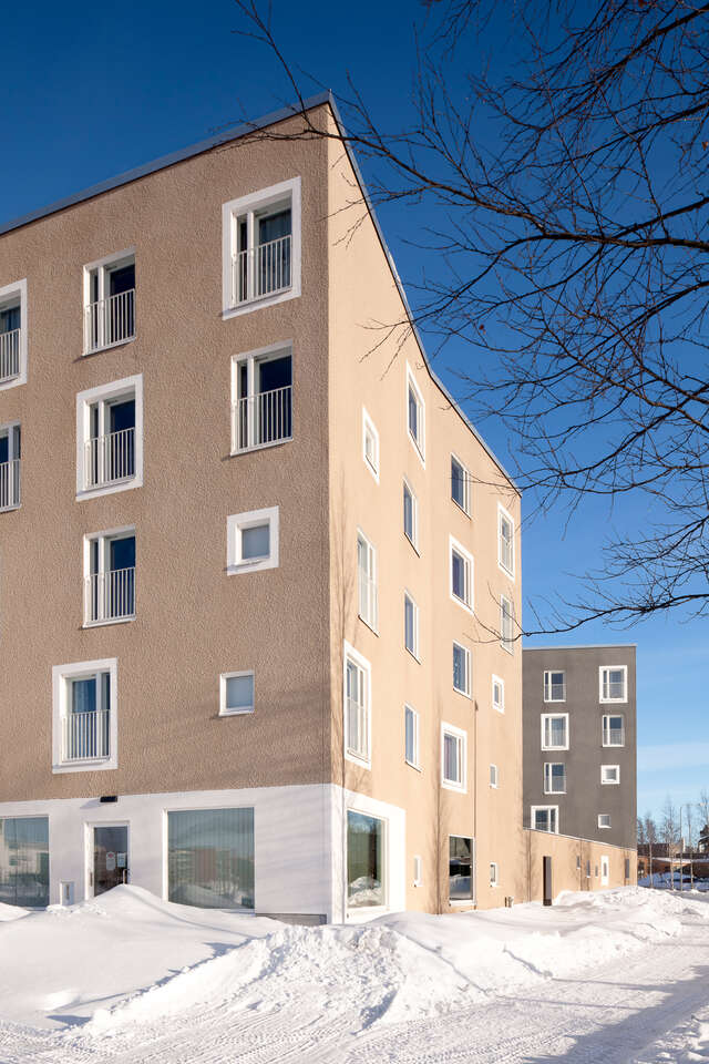 Beige and grey five-storey block houses in snowy landscape