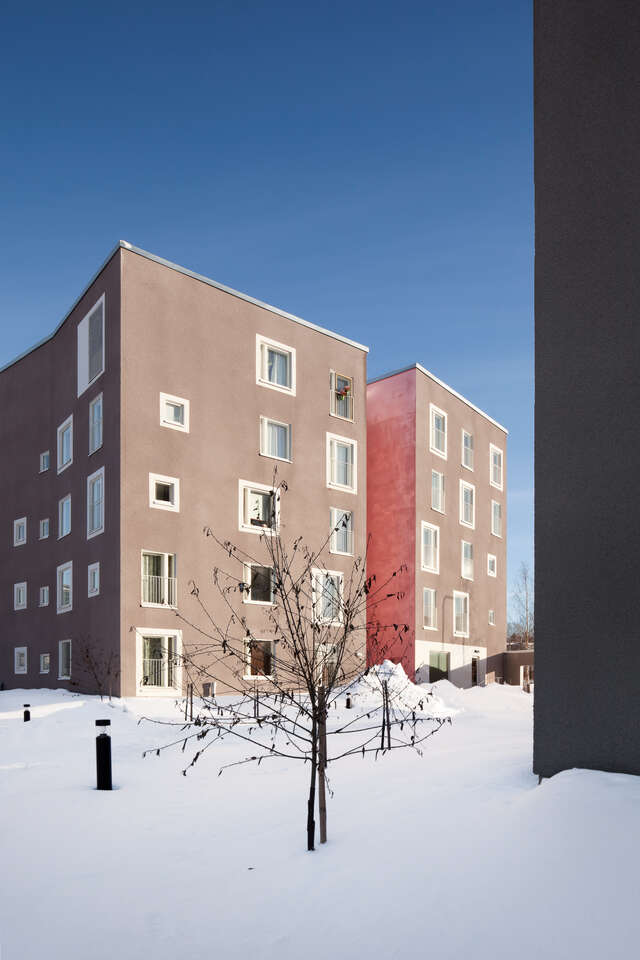 Two grey five-storey block-houses in a snowy landscape