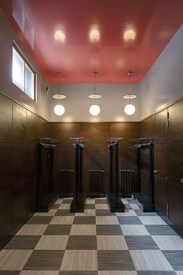 Wardrobe room with dark wooden panels and a pink roof.