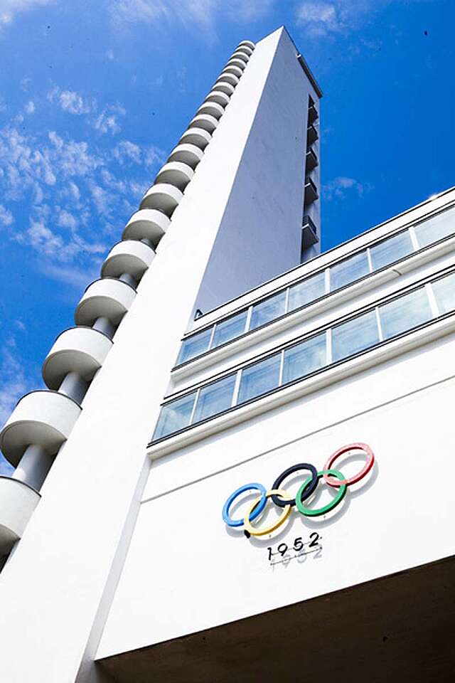 White tower side façade with olympic rings and ribbon windows