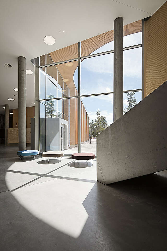 Colorful benches in front of a window wall and concrete stairs.